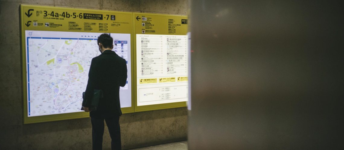 man-checking-bulletin-board-station-scaled